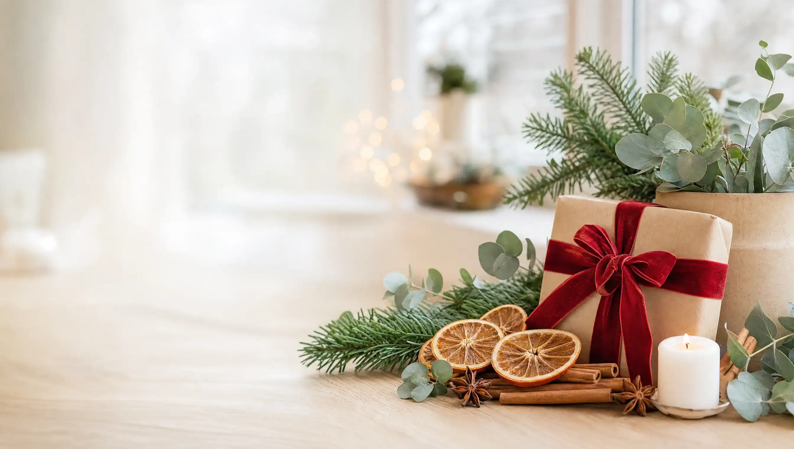 Weihnachtlich geschmücktes Geschenk mit Tannengrün, Orangenscheiben und Kerze